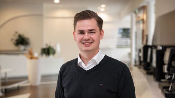 Mitarbeiter lächelnd im Forum bei Kaffee Partner