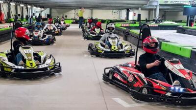 Auszubildende beim Go-Kart-Fahren als Teambuilding-Maßnahme in einer Indoor-Kartbahn