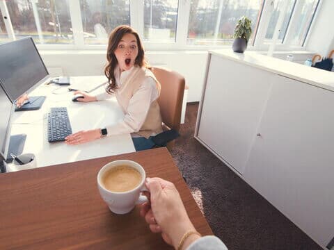 Mitarbeiterin freut sich über Kaffee Partner Kaffee Wertschätzung bei Kaffee Partner: Kollegin bringt Kaffee mit